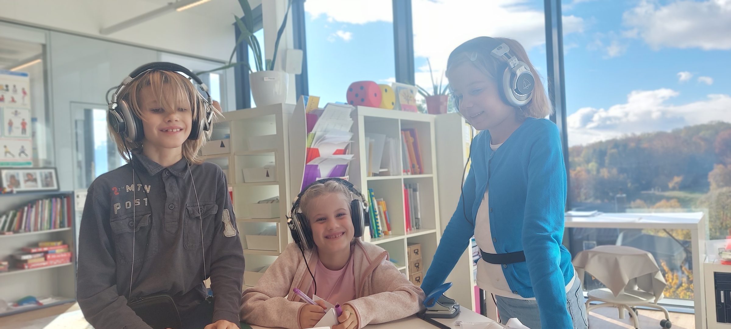 Trois enfants équipés de casques Tomatis lors d'une séance en établissement scolaire