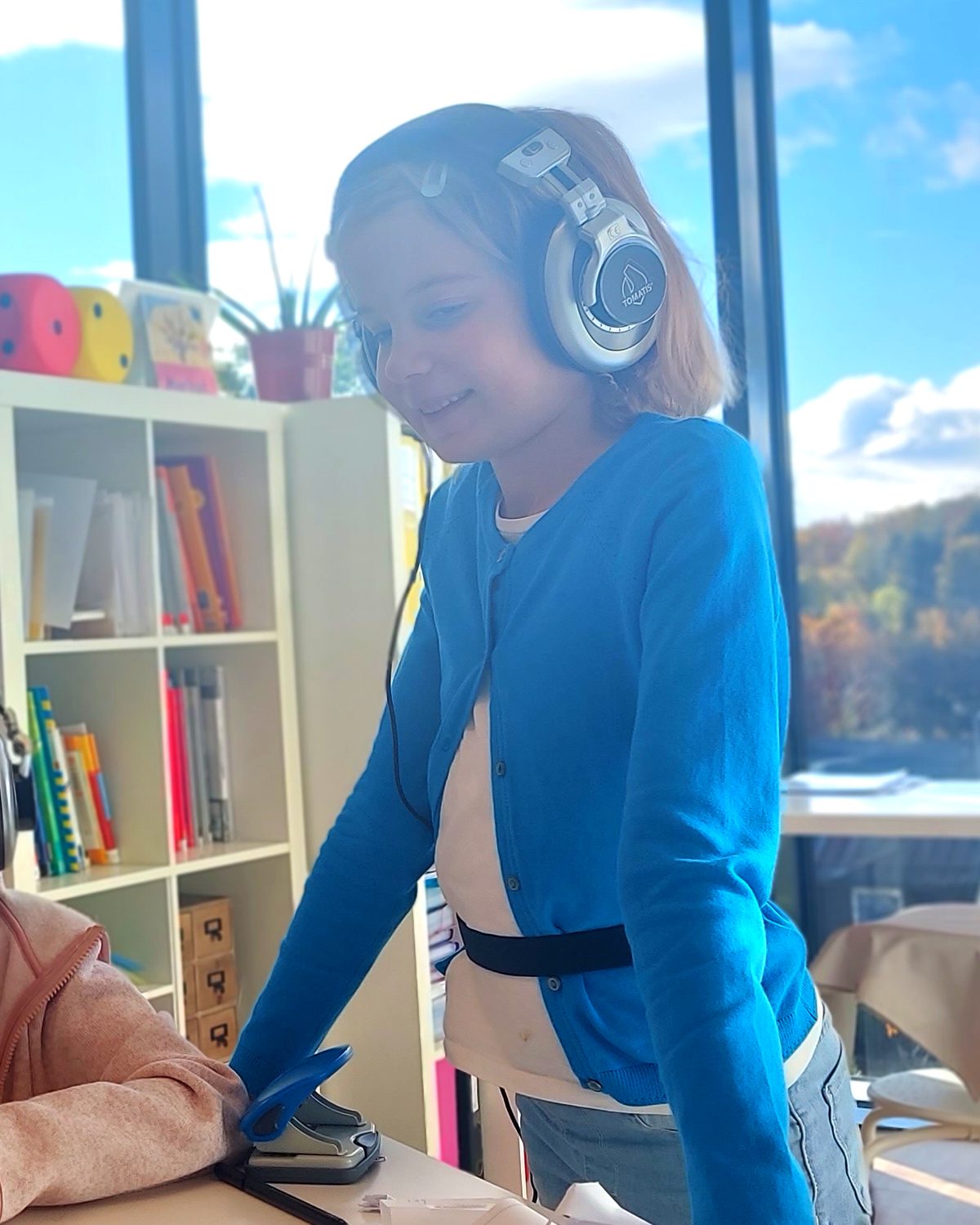 Enfant équipée d'un casque d'écoute dans sa salle de classe